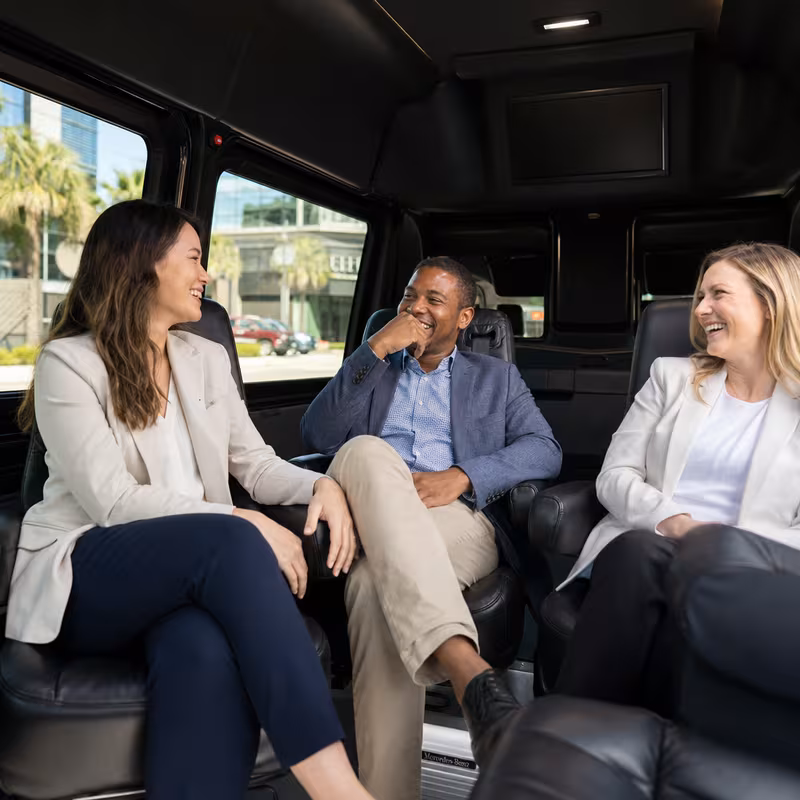 Group boarding a white charter bus for Corporate Transportation transportation in Fullerton