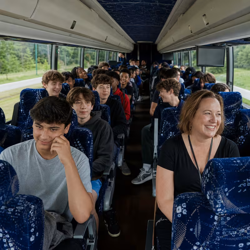 Group boarding a white charter bus for School Transportation transportation in Fullerton