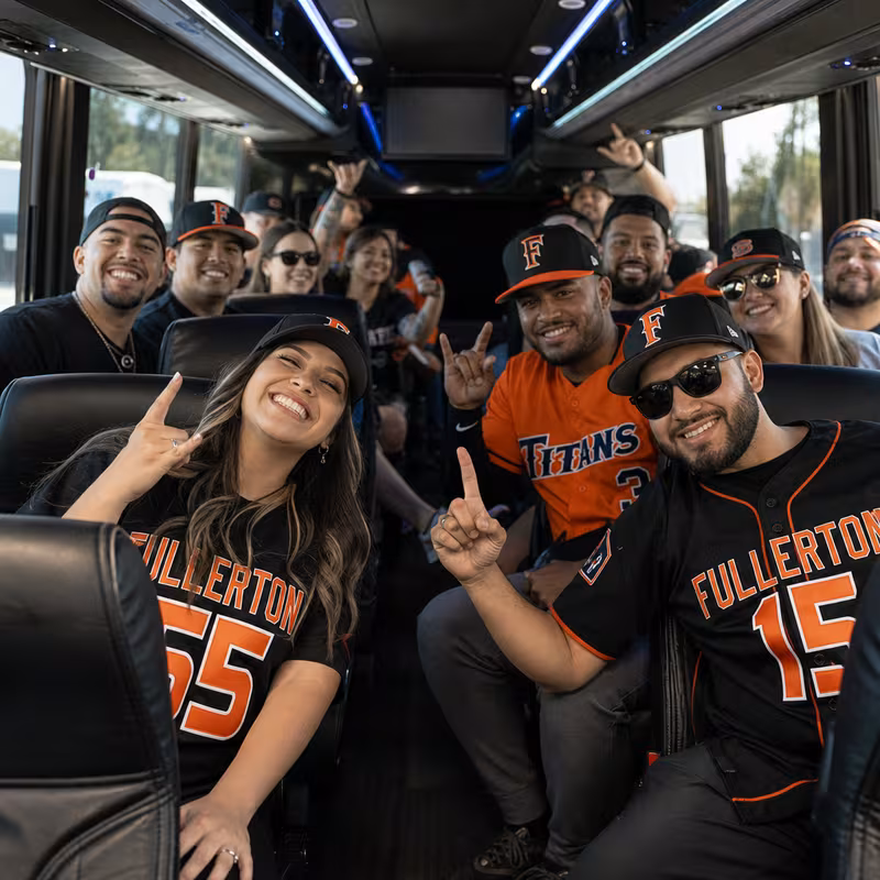 Group boarding a white charter bus for Sporting Event Transportation transportation in Fullerton