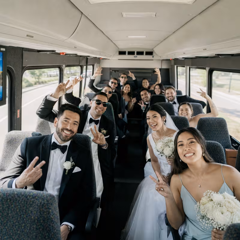 Group boarding a white charter bus for Wedding Transportation transportation in Fullerton